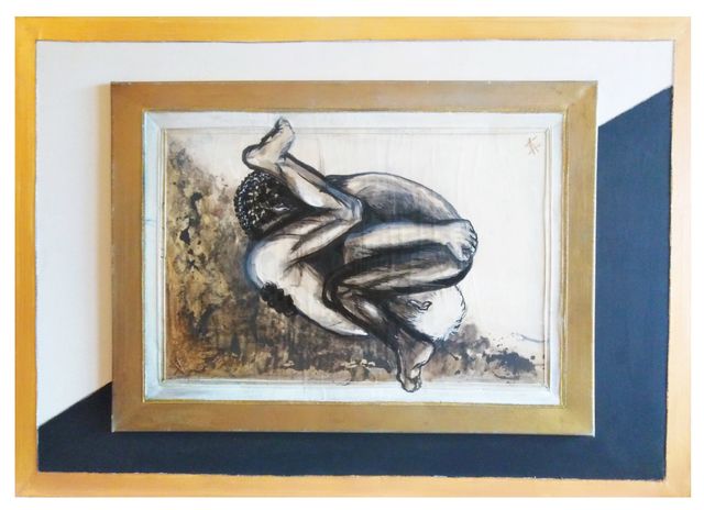 A sepia figure study of a nude man curled into a fetal ball on cream fabric, in a gold frame set diagonally over geometric panels.