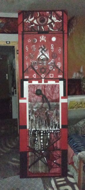 A tall narrow red, black and white panel: an all-seeing eye above rows of painted symbols — a burning yin-yang, stars, moons, infinity signs — over a bowed silhouetted figure.